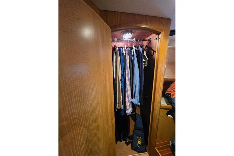  Yacht Photos Pics Clothing closet inside 1993 McKinna 48 Pilothouse yacht, featuring wooden interior and hanging garments.