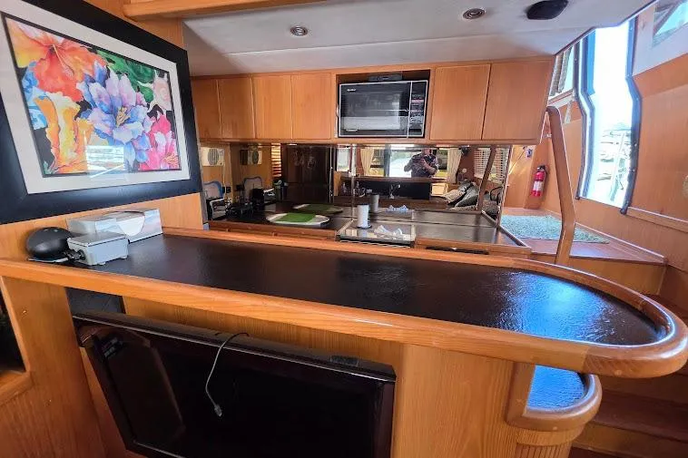  Yacht Photos Pics 1993 McKinna 48 Pilothouse interior with kitchen, wooden cabinetry, and colorful artwork.