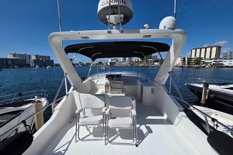  Yacht Photos Pics 1993 McKinna 48 Pilothouse yacht with spacious deck, docked in a marina under clear blue skies.