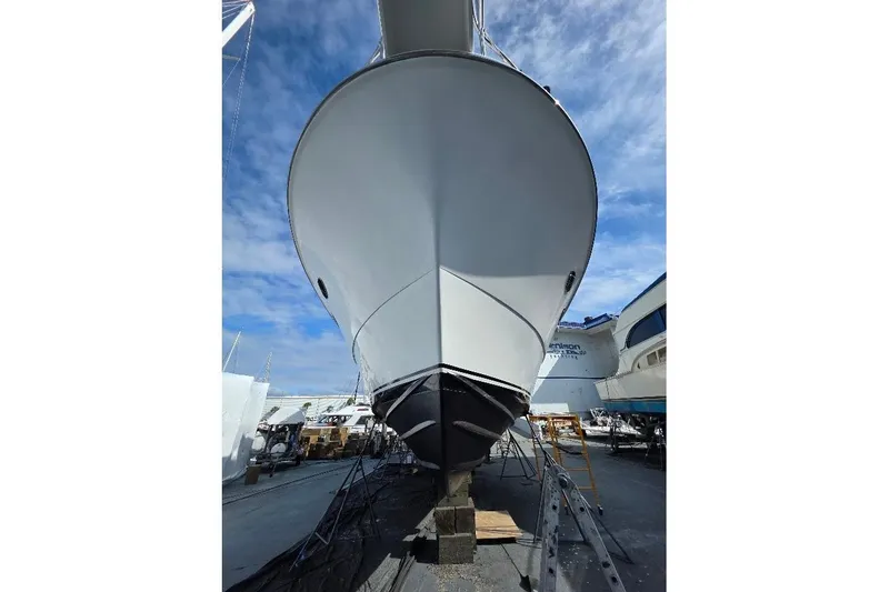  Yacht Photos Pics 1993 McKinna 48 Pilothouse yacht on dry dock under a clear blue sky.