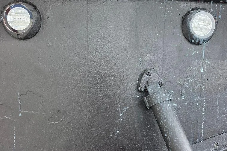  Yacht Photos Pics Black hull of 1993 McKinna 48 Pilothouse with circular fixtures and pipe detail.