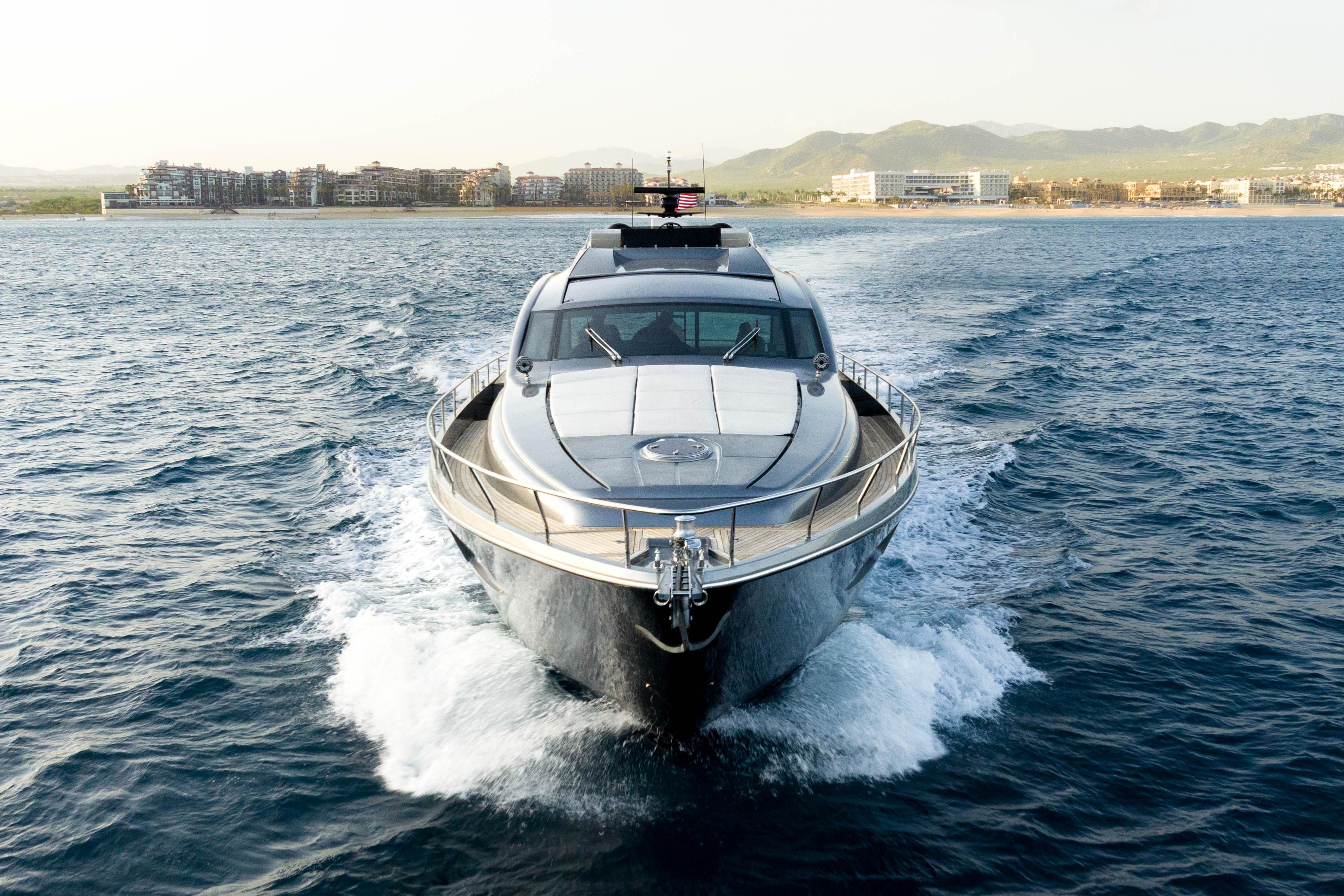 2017 Pershing 74 yacht cruising on open water near coastal cityscape.