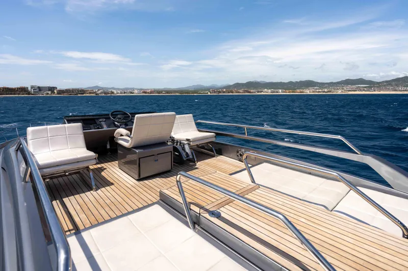 One Spin 2 Yacht Photos Pics 2017 Pershing 74 yacht deck with seating, overlooking ocean and distant coastline.