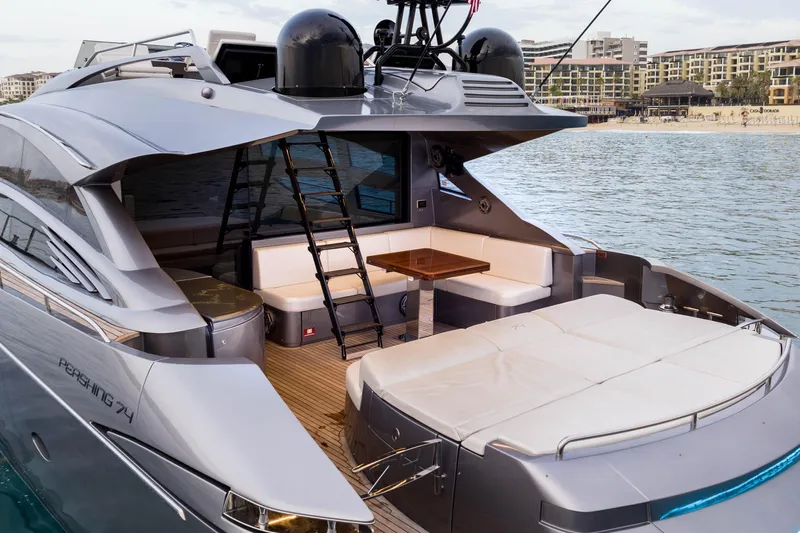 One Spin 2 Yacht Photos Pics Luxury 2017 Pershing 74 yacht with spacious deck and seating area, docked by the water.