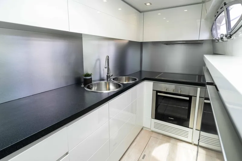 One Spin 2 Yacht Photos Pics Modern kitchen interior on 2017 Pershing 74 yacht, featuring sleek design and stainless steel appliances.