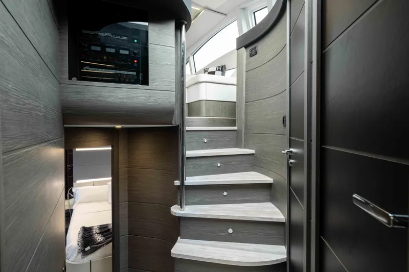 One Spin 2 Yacht Photos Pics Interior of 2017 Pershing 74 yacht, featuring modern staircase and luxurious cabin.