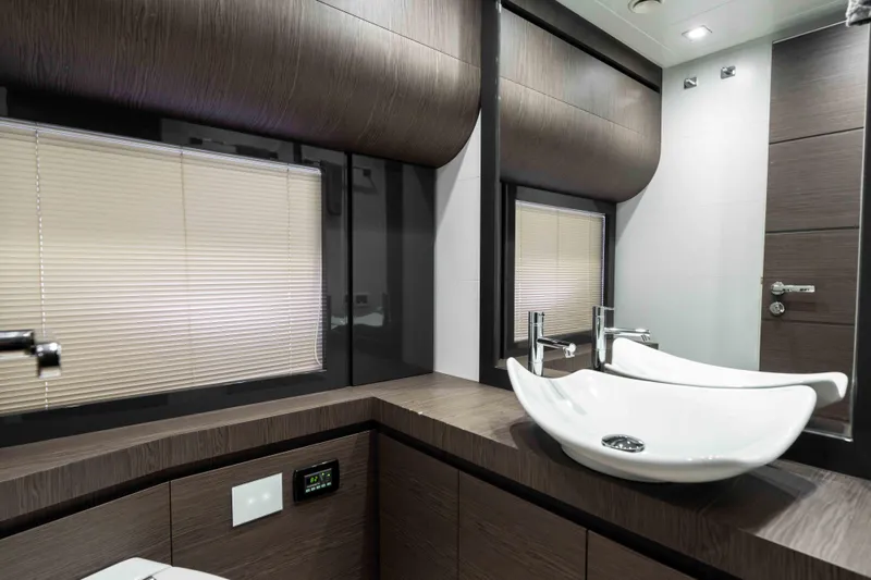 One Spin 2 Yacht Photos Pics Luxurious bathroom interior of 2017 Pershing 74 yacht with modern sink and wood accents.