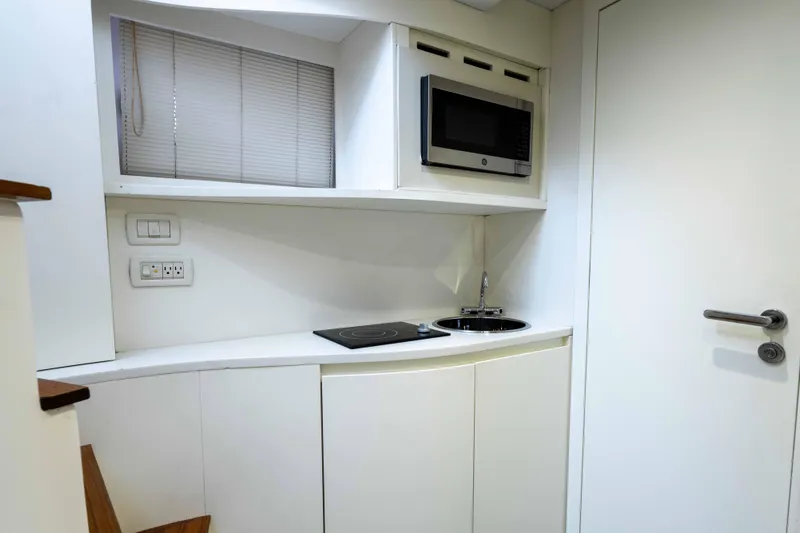 One Spin 2 Yacht Photos Pics Compact kitchen area in a 2017 Pershing 74 yacht with microwave and sink.