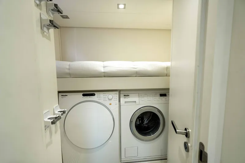 One Spin 2 Yacht Photos Pics Laundry area with Miele appliances and a bunk bed in a 2017 Pershing 74 yacht.