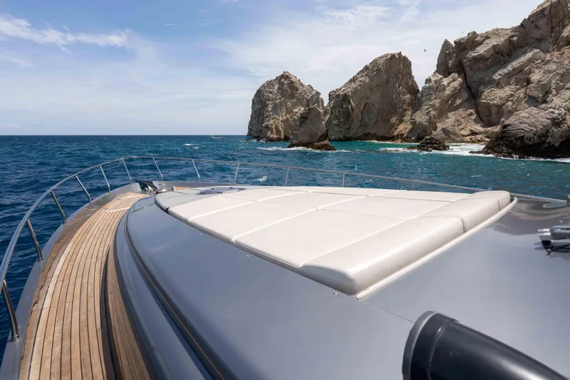 One Spin 2 Yacht Photos Pics 2017 Pershing 74 yacht cruising near rocky coastline under clear skies.