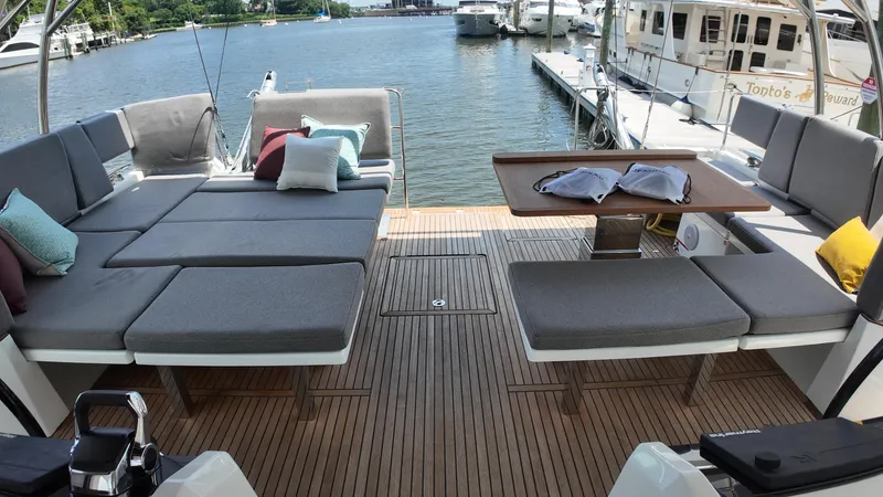  Yacht Photos Pics Luxurious 2024 Jeanneau 55 yacht deck with comfortable seating and elegant wooden flooring.