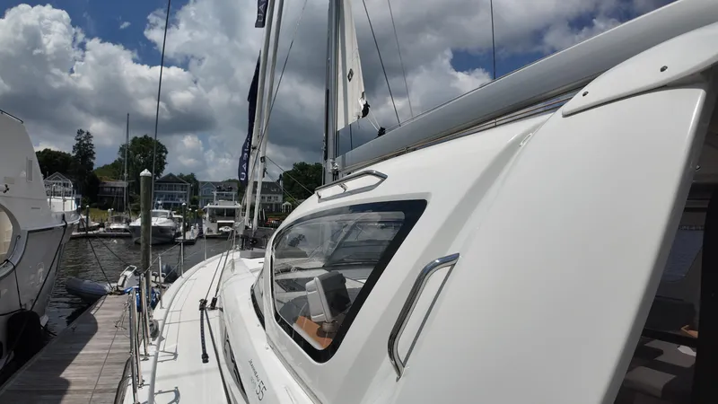  Yacht Photos Pics 2024 Jeanneau 55 sailboat docked at marina under cloudy sky.
