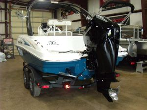 2025 Tahoe 2150 CC boat with outboard motor in a showroom.