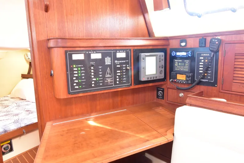 Aftia Yacht Photos Pics Navigation station on a 1999 Island Packet 380 sailboat with control panels and equipment.