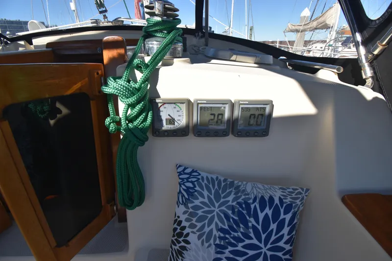 Aftia Yacht Photos Pics 1999 Island Packet 380 cockpit with gauges, green rope, and decorative pillow.