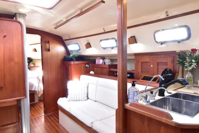 Aftia Yacht Photos Pics Interior of 1999 Island Packet 380 sailboat with wood finish and cozy seating area.