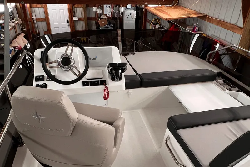  Yacht Photos Pics 2021 Jeanneau NC 1095 FLY boat helm station with cushioned seating in a storage shed.