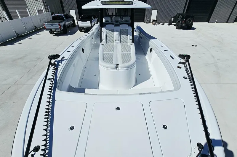  Yacht Photos Pics 2025 Costa Custom Boats 34ST, sleek white design, docked with vehicles in the background.