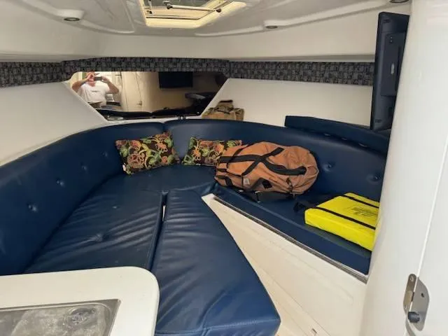 2003 Intrepid 31 Walkaround Yacht Photos Pics Interior of 2003 Intrepid 31 Walkaround with blue seating and colorful pillows.