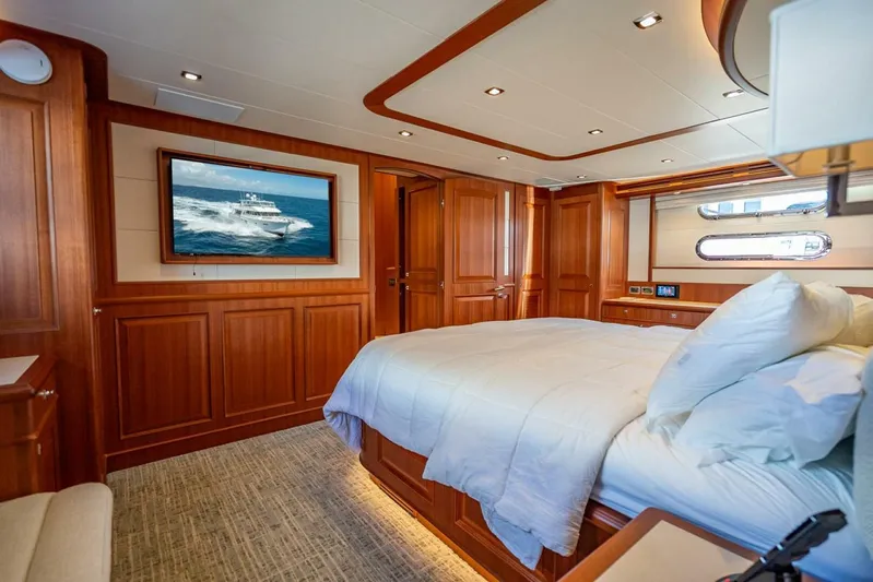 Sunny Seajay Yacht Photos Pics Luxurious bedroom interior of 2022 Hampton 658l Endurance yacht with wood paneling and modern amenities.