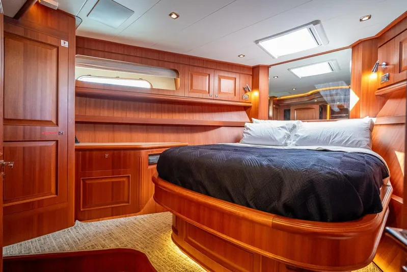 Sunny Seajay Yacht Photos Pics Luxurious cabin interior of 2022 Hampton 658l Endurance yacht with wood paneling and cozy bed.