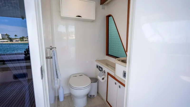 Sunny Seajay Yacht Photos Pics 2022 Hampton 658l Endurance yacht bathroom with toilet, sink, and window view.