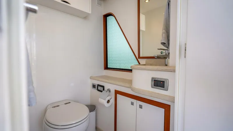 Sunny Seajay Yacht Photos Pics Modern bathroom in 2022 Hampton 658l Endurance yacht with toilet, sink, and storage cabinets.