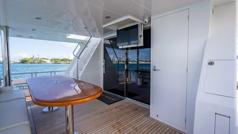 Sunny Seajay Yacht Photos Pics Luxury yacht deck with wooden table, modern design, and ocean view. Hampton 658l Endurance 2022.