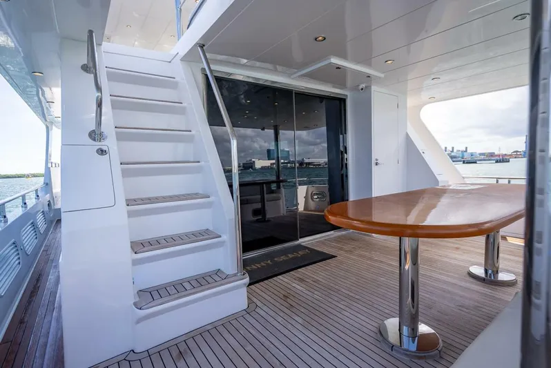 Sunny Seajay Yacht Photos Pics Luxury yacht deck with stairs, table, and ocean view; Hampton 658l Endurance 2022 model.