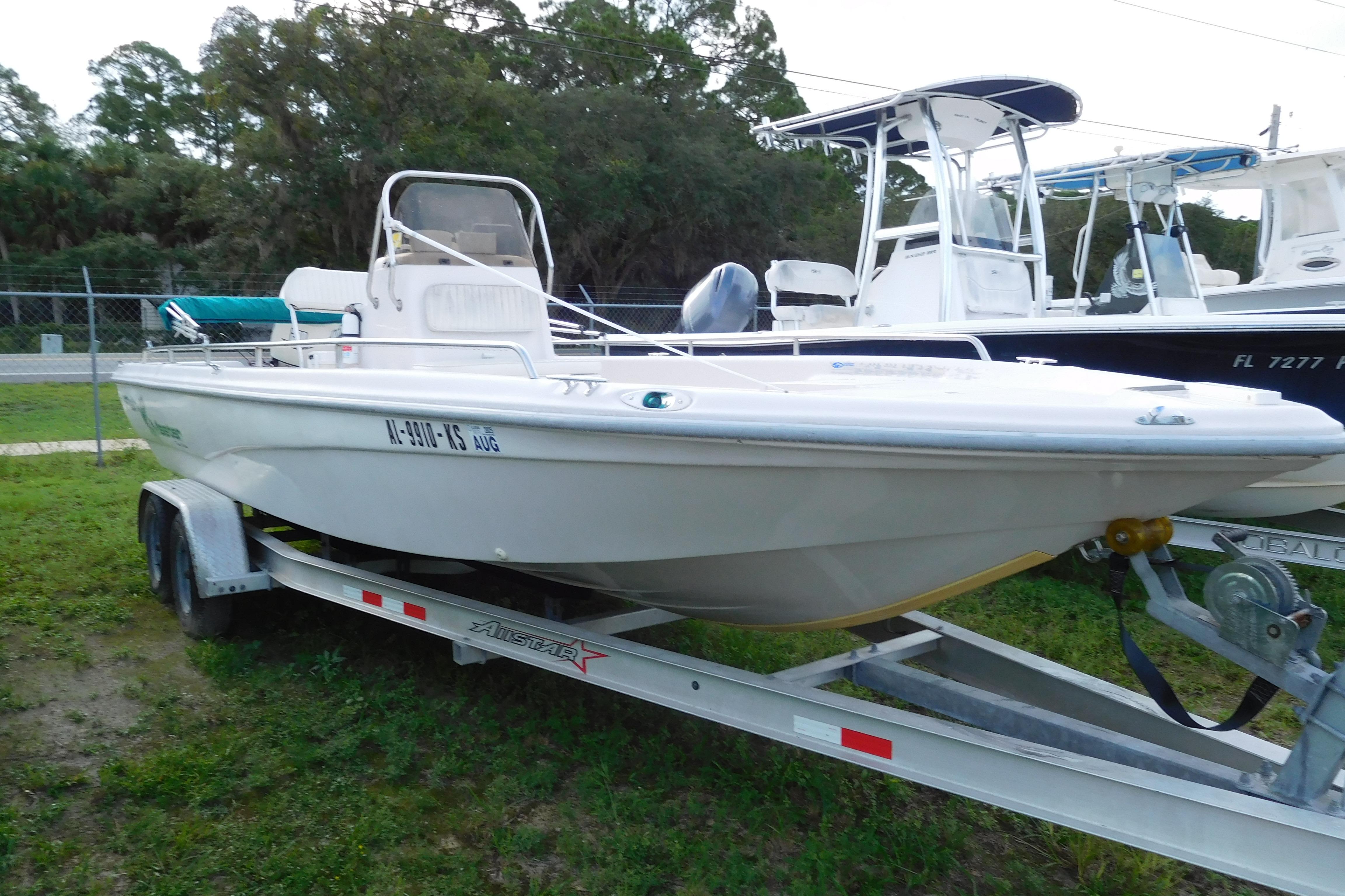 2002 Fishmaster 22 BAY boat on trailer, parked outdoors.
