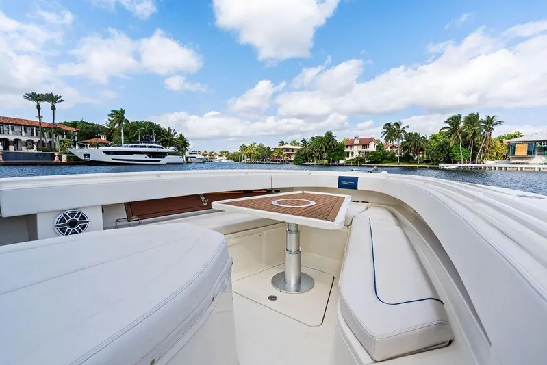 Acevedo Yacht Photos Pics 2016 Hydrosport Siesta boat interior with seating and table, docked near waterfront homes.