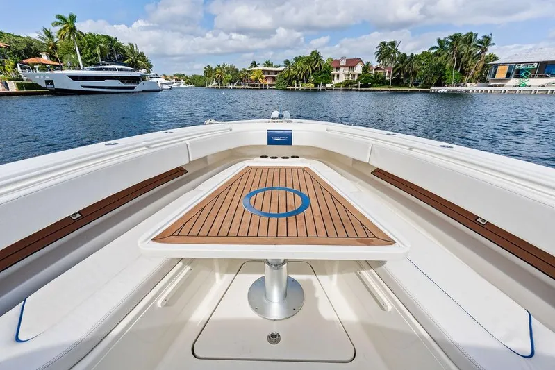 Acevedo Yacht Photos Pics 2016 Hydrosport Siesta boat with wooden deck table, docked in a scenic marina.