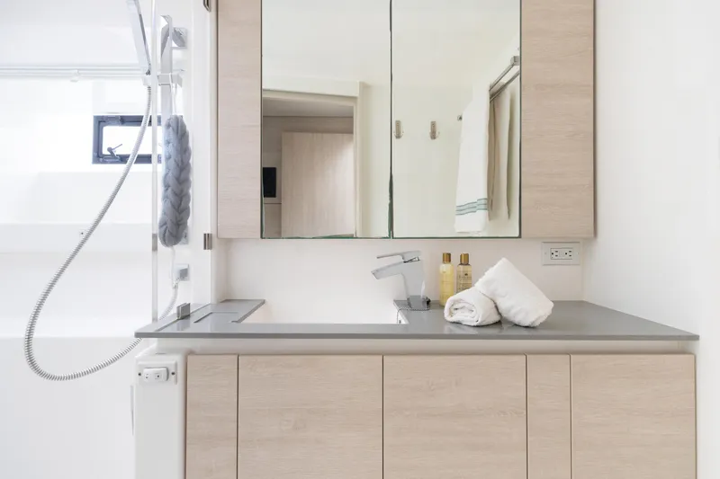  Yacht Photos Pics Modern bathroom vanity with mirror, light wood cabinets, and sleek countertop in Leopard 50 yacht.