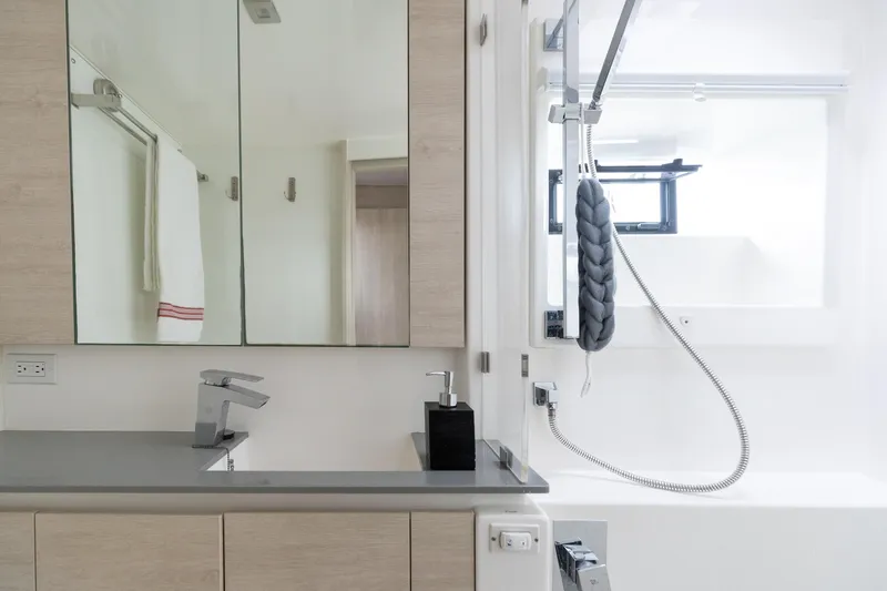  Yacht Photos Pics Modern bathroom with sleek fixtures, mirrored cabinet, and shower in a Leopard 50 yacht, 2021 model.