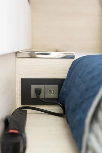  Yacht Photos Pics Power outlet and USB ports on Leopard 50 yacht, 2021 model, with blue cushion nearby.