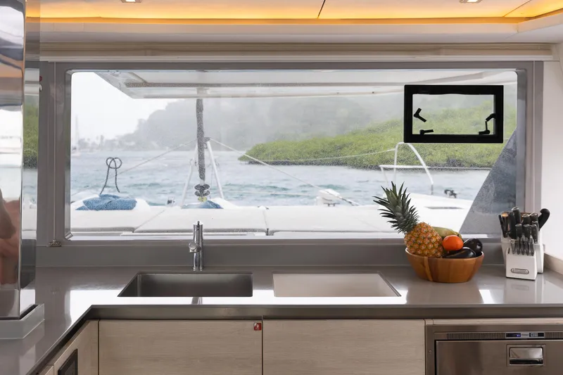  Yacht Photos Pics Modern kitchen interior on Leopard 50 yacht, featuring a large window with ocean view.