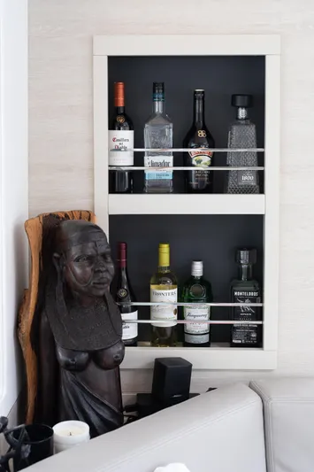  Yacht Photos Pics Wall-mounted liquor shelf with various bottles and a wooden sculpture, Leopard 50, 2021.