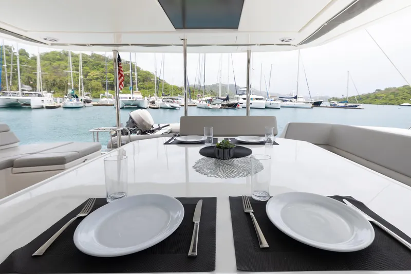  Yacht Photos Pics Dining area on Leopard 50 yacht, set for two, overlooking marina with sailboats.