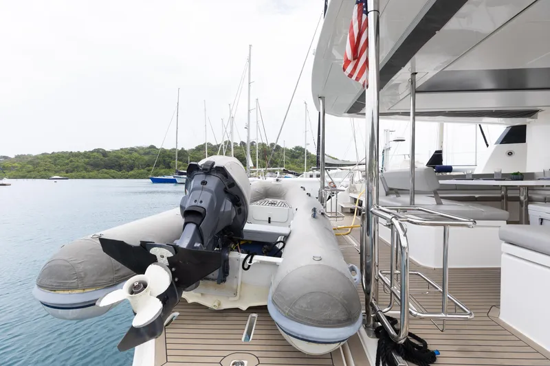  Yacht Photos Pics 2021 Leopard 50 yacht with dinghy and American flag, docked in a serene marina.