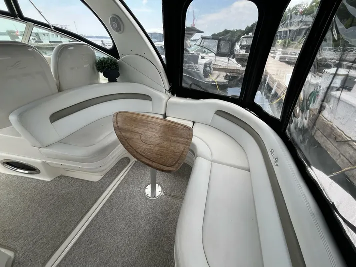  Yacht Photos Pics Interior of 2007 Sea Ray 340 Sundancer with curved seating and wooden table.
