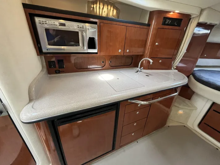  Yacht Photos Pics 2007 Sea Ray 340 Sundancer galley with microwave, sink, and wooden cabinetry.