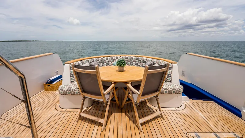 Bravo Yacht Photos Pics Deck of 1975 Stephens Brothers Expedition yacht with wooden table and ocean view.