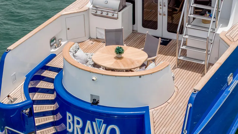 Bravo Yacht Photos Pics Luxury yacht deck with seating area, wooden table, and grill, Stephens Brothers Expedition 1975.