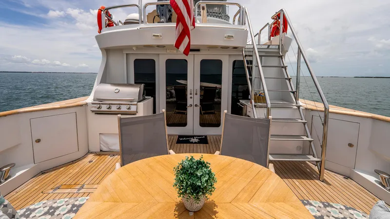 Bravo Yacht Photos Pics 1975 Stephens Brothers Expedition yacht deck with dining area, grill, and ocean view.