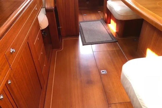 Dark N' Stormy III Yacht Photos Pics Interior of 1999 Sweden Yachts 45, featuring polished wood flooring and cushioned seating.