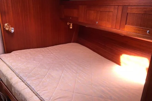 Dark N' Stormy III Yacht Photos Pics Cozy cabin interior of 1999 Sweden Yachts 45 with wooden finish and comfortable bedding.