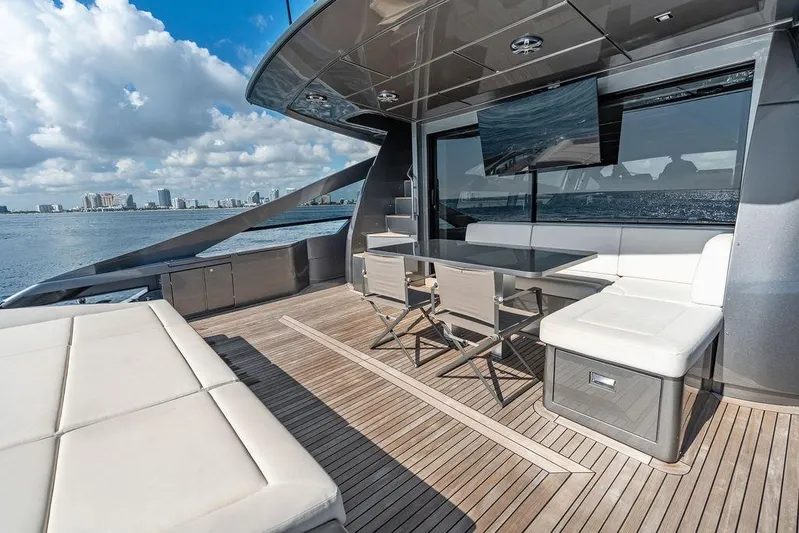One Spin 3 Yacht Photos Pics Luxurious 2019 Pershing 9X yacht deck with seating, table, and ocean view.