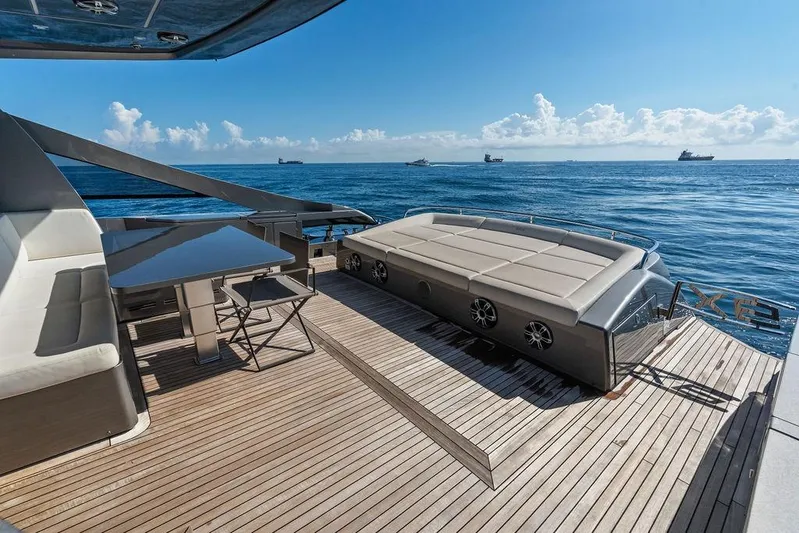 One Spin 3 Yacht Photos Pics Luxurious 2019 Pershing 9X yacht deck with seating, table, and ocean view.