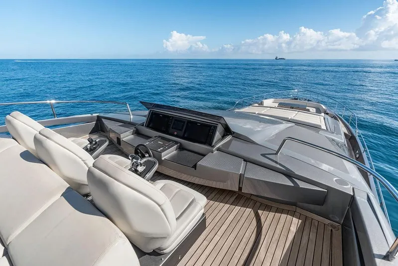 One Spin 3 Yacht Photos Pics Luxurious 2019 Pershing 9X yacht deck with helm, overlooking serene ocean waters.
