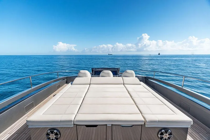 One Spin 3 Yacht Photos Pics Luxurious 2019 Pershing 9X yacht deck with sunbed, ocean view, and clear blue sky.